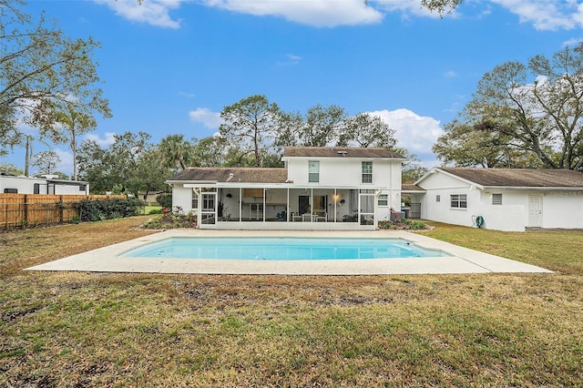 rear view of property with a patio area, a fenced in pool, a sunroom, and a yard