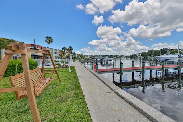 dock area with a water view and a lawn