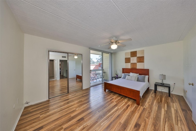 bedroom featuring dark hardwood / wood-style flooring, access to exterior, a textured ceiling, and ceiling fan