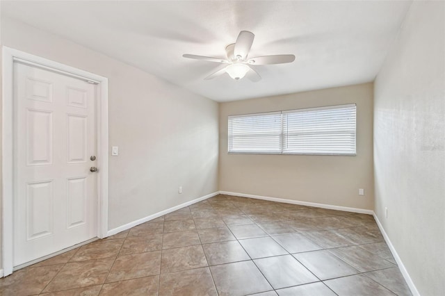 tiled spare room featuring ceiling fan