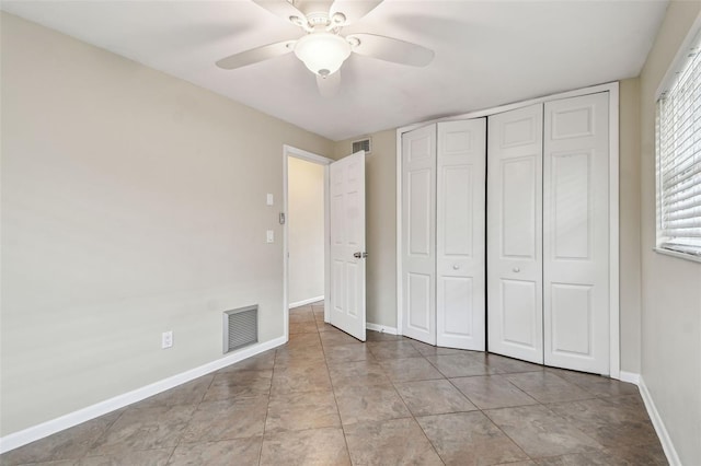 unfurnished bedroom with ceiling fan and a closet