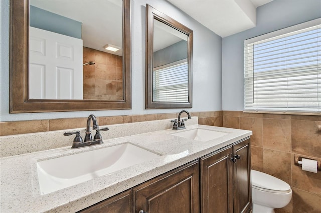 bathroom featuring tile walls, toilet, and vanity