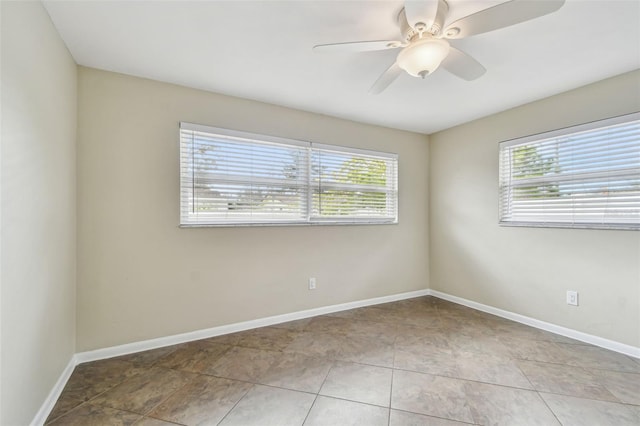 tiled spare room featuring ceiling fan