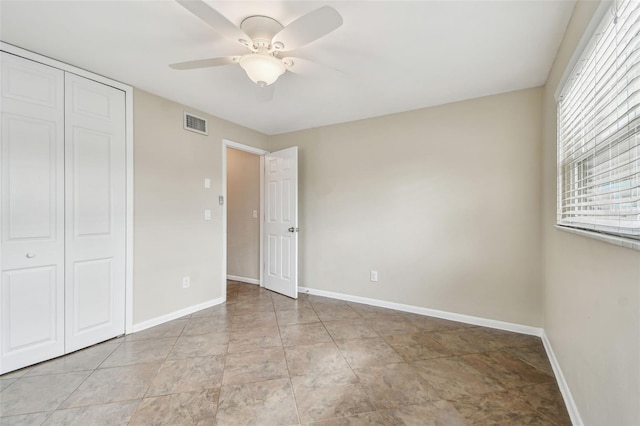 unfurnished bedroom featuring ceiling fan and a closet