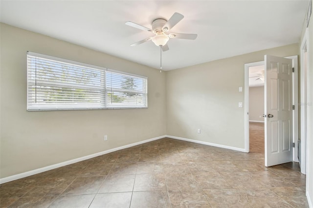 empty room with ceiling fan and light tile patterned flooring