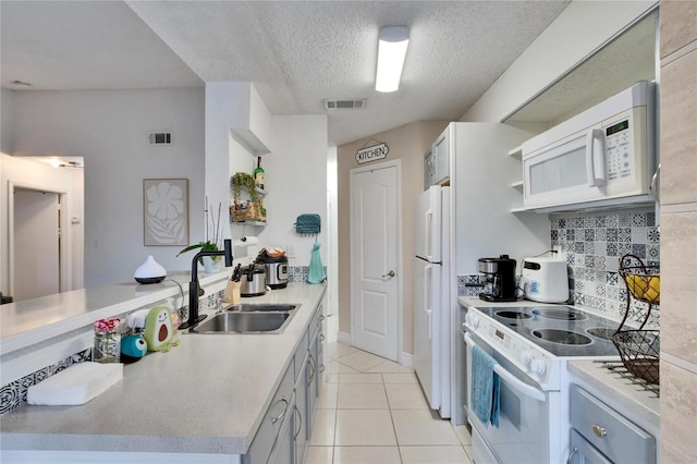 kitchen featuring light tile patterned flooring, sink, a textured ceiling, white appliances, and decorative backsplash