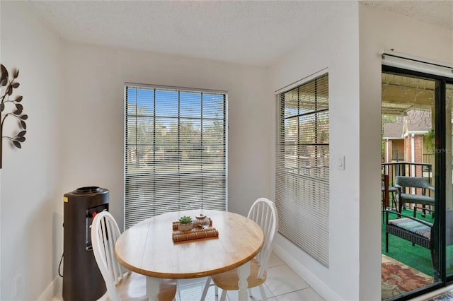 tiled dining space with a textured ceiling