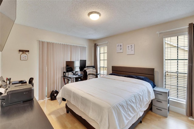 bedroom featuring light hardwood / wood-style flooring and a textured ceiling