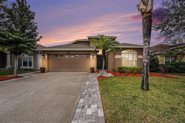 view of front of home featuring a garage and a yard