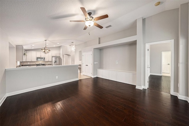 unfurnished living room with dark hardwood / wood-style flooring, sink, and ceiling fan