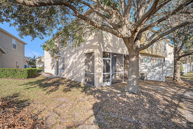 view of side of property featuring a sunroom and a yard