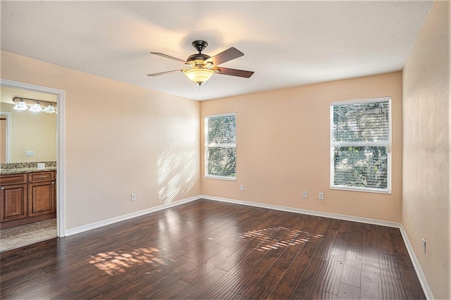 empty room with dark hardwood / wood-style floors and ceiling fan