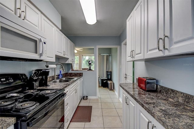 kitchen featuring sink, white cabinetry, light tile patterned floors, and black electric range