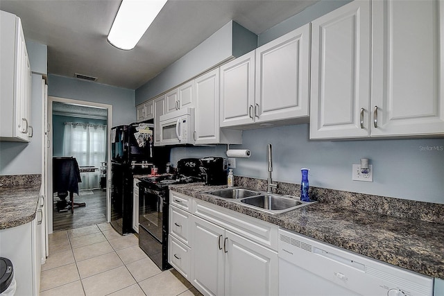 kitchen featuring black appliances, white cabinets, light tile patterned floors, and sink