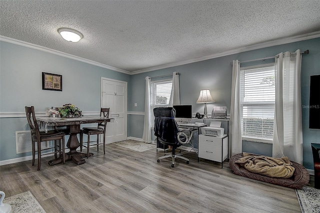 office area featuring light wood-type flooring, a wealth of natural light, and ornamental molding