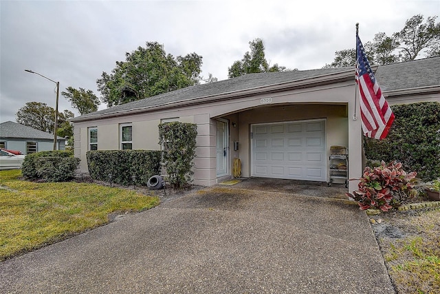 single story home with a garage and a front lawn