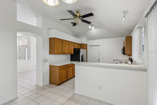 kitchen featuring stainless steel refrigerator with ice dispenser, lofted ceiling, ceiling fan, and kitchen peninsula