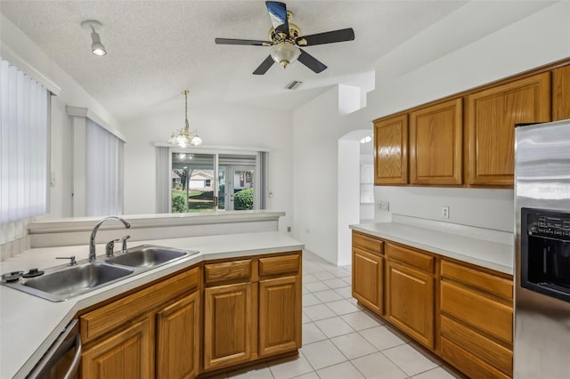 kitchen with lofted ceiling, sink, decorative light fixtures, a textured ceiling, and stainless steel appliances