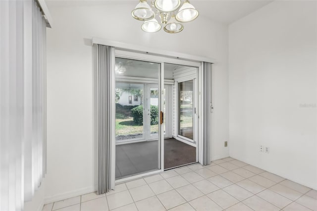 tiled spare room featuring a chandelier