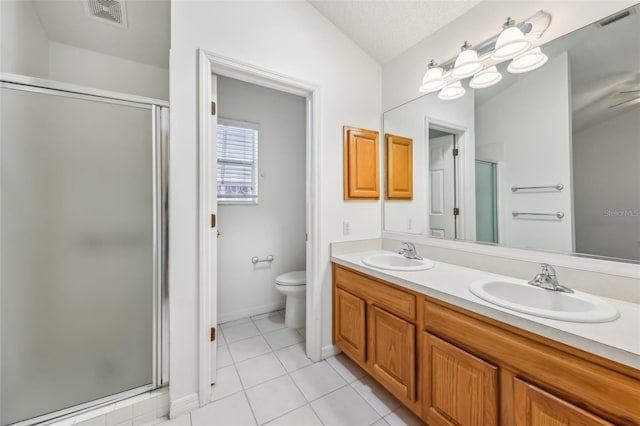 bathroom featuring toilet, an enclosed shower, a textured ceiling, vanity, and tile patterned flooring