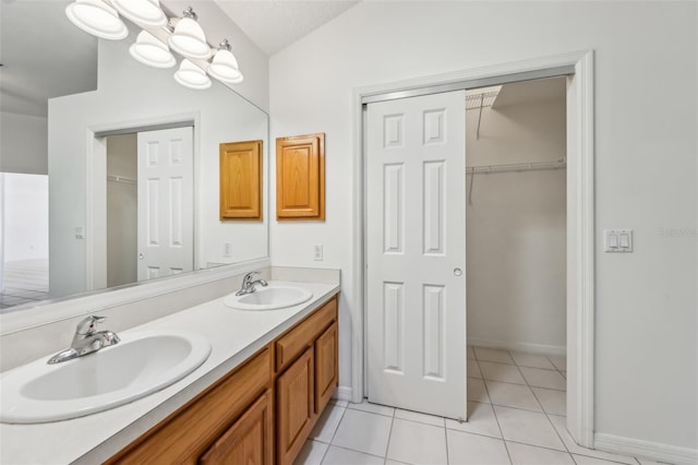 bathroom with tile patterned flooring, vanity, vaulted ceiling, and a textured ceiling