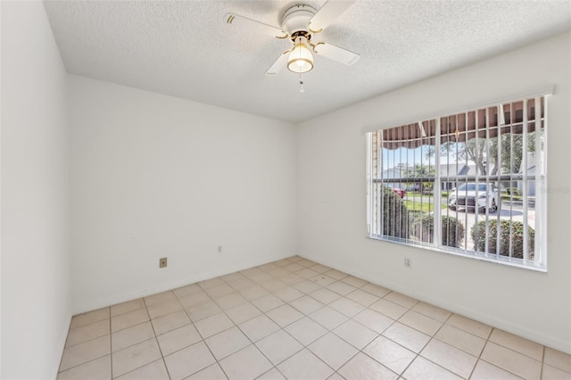 tiled empty room featuring a textured ceiling and ceiling fan