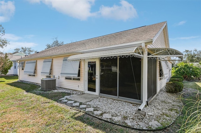 rear view of house featuring a yard and central AC unit