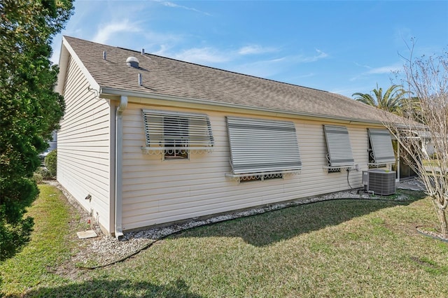 view of side of home with a yard and central air condition unit