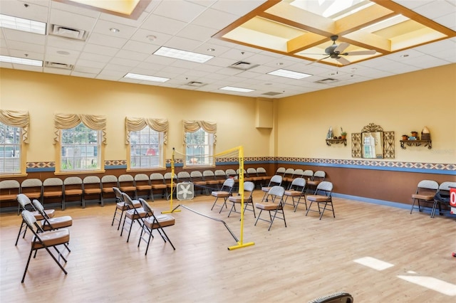 playroom featuring wood-type flooring, a paneled ceiling, and ceiling fan