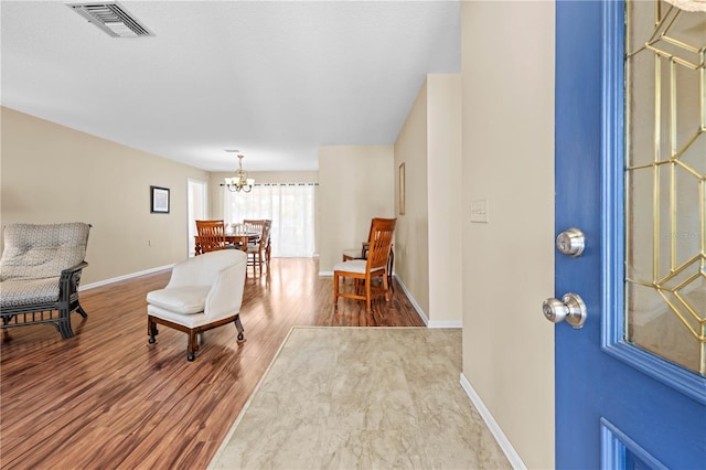 foyer entrance with hardwood / wood-style flooring and a notable chandelier