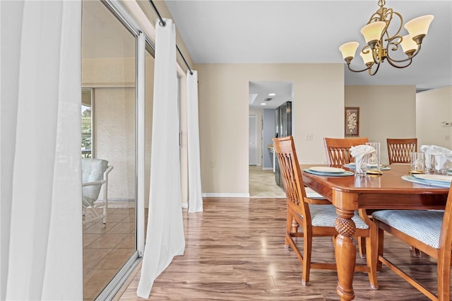 dining area featuring light hardwood / wood-style floors and a chandelier