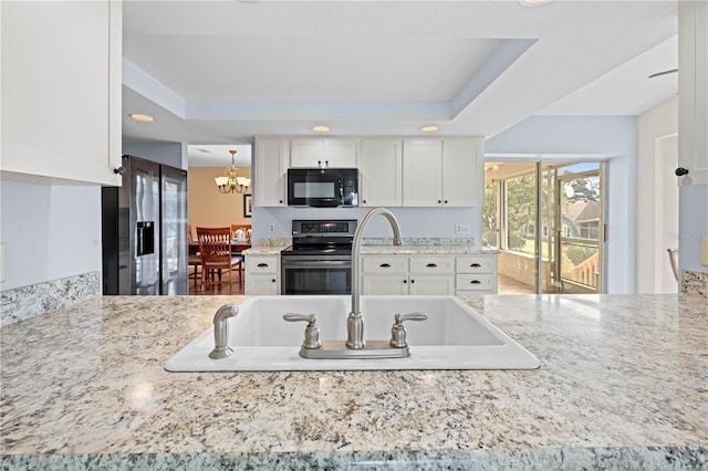 kitchen featuring decorative light fixtures, white cabinets, a notable chandelier, electric range, and a raised ceiling