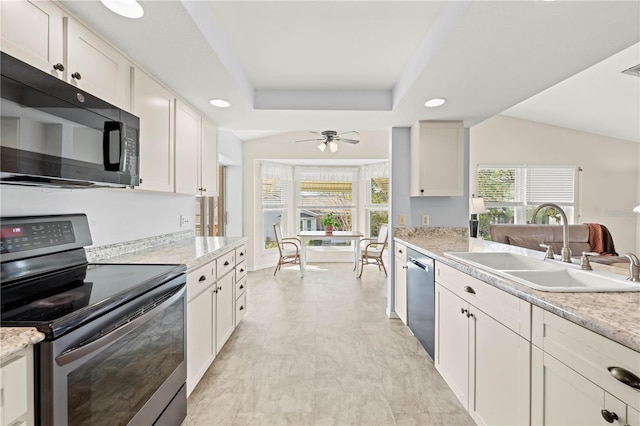 kitchen with sink, appliances with stainless steel finishes, a raised ceiling, ceiling fan, and white cabinets