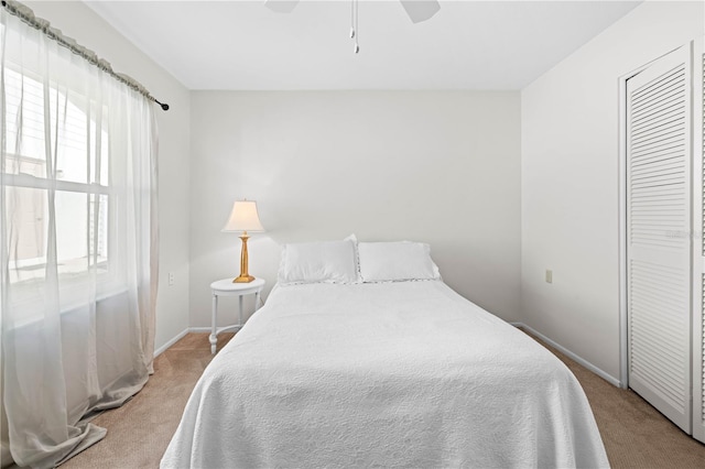 bedroom featuring multiple windows, carpet flooring, ceiling fan, and a closet