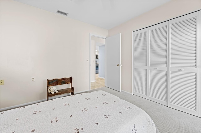 bedroom with light carpet and a closet