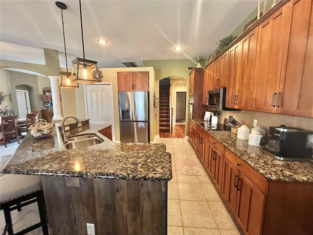 kitchen with pendant lighting, sink, a large island, light tile patterned floors, and stainless steel appliances