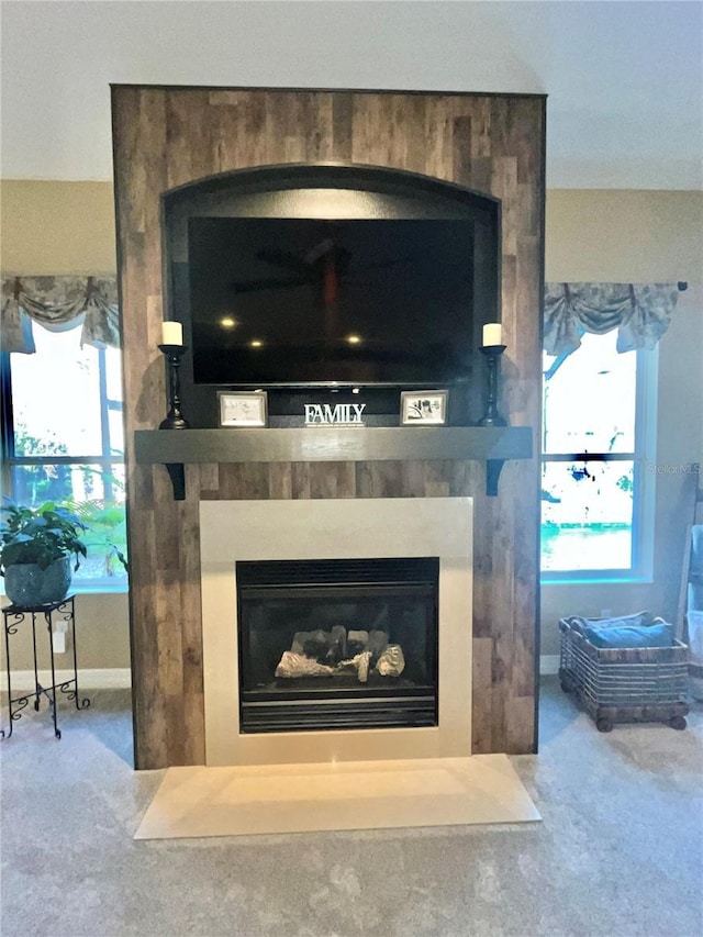 room details featuring a large fireplace and carpet floors