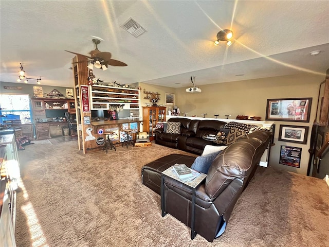 living room featuring ceiling fan, carpet flooring, and a textured ceiling