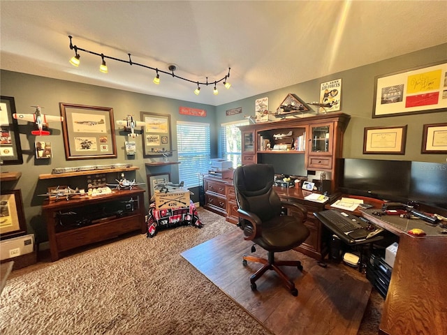 carpeted office featuring rail lighting