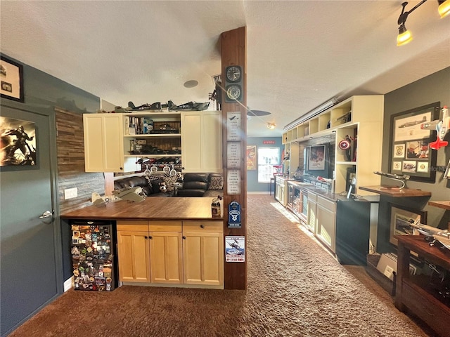 kitchen with wine cooler, a textured ceiling, and dark colored carpet