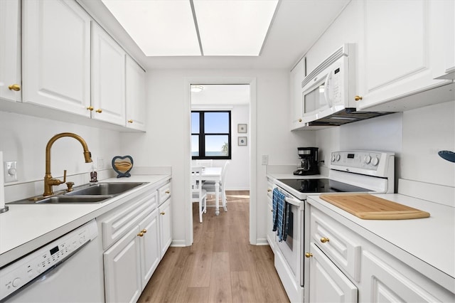 kitchen featuring sink, white cabinets, white appliances, and light hardwood / wood-style floors