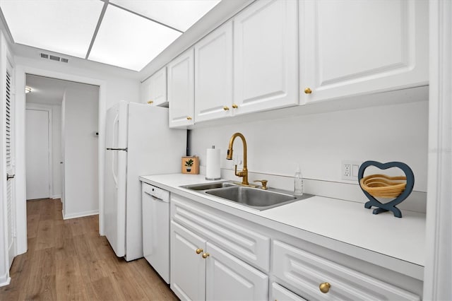 kitchen featuring white cabinets, sink, dishwasher, and light wood-type flooring