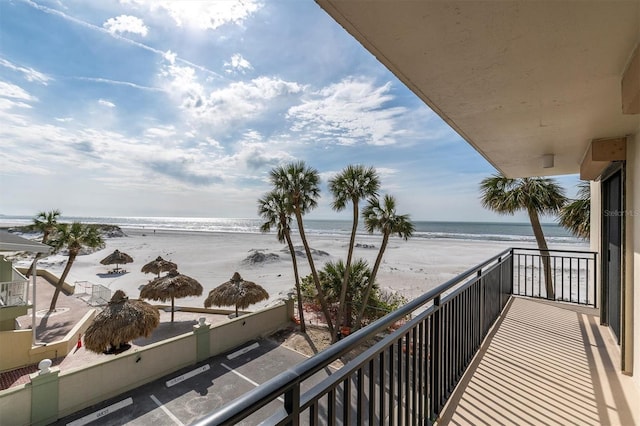 balcony featuring a water view and a beach view