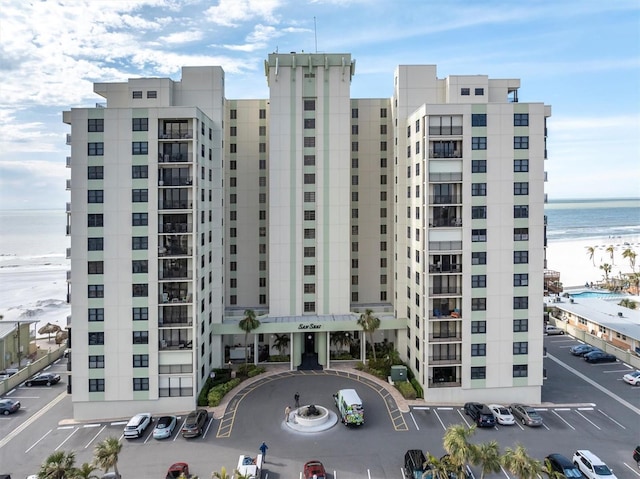 view of building exterior with a water view and a view of the beach