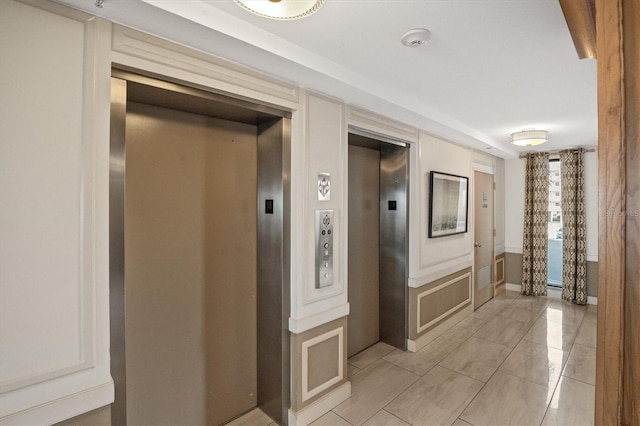 hall featuring elevator and light tile patterned floors