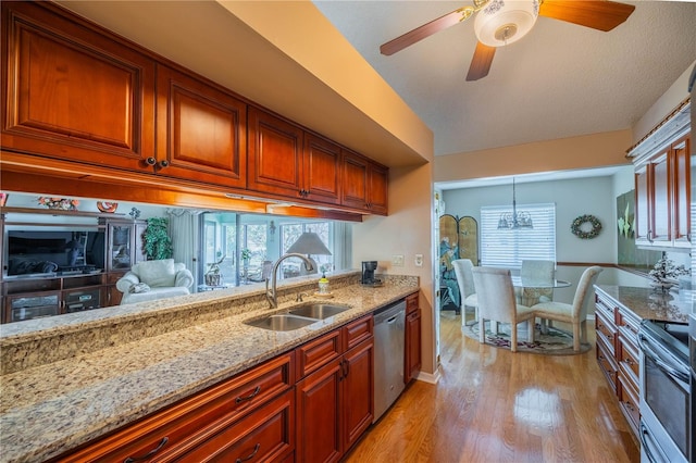 kitchen featuring sink, decorative light fixtures, stainless steel appliances, light stone countertops, and light hardwood / wood-style floors