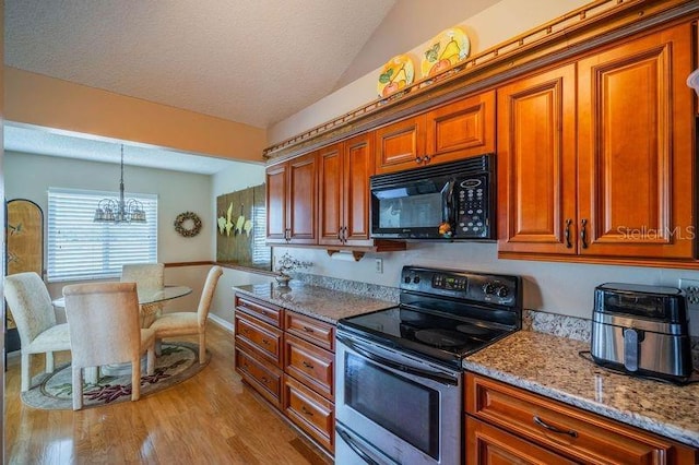 kitchen with pendant lighting, stainless steel electric range, light hardwood / wood-style flooring, light stone countertops, and a chandelier