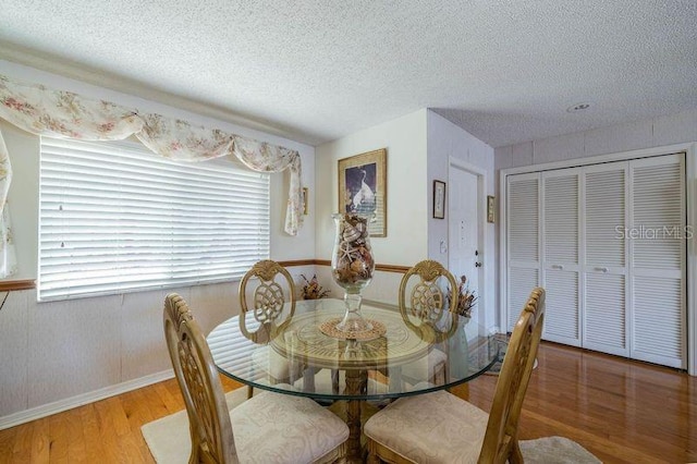 dining space featuring a textured ceiling and light wood-type flooring