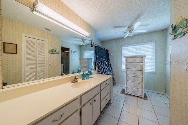 bathroom with ceiling fan, a wealth of natural light, and a textured ceiling