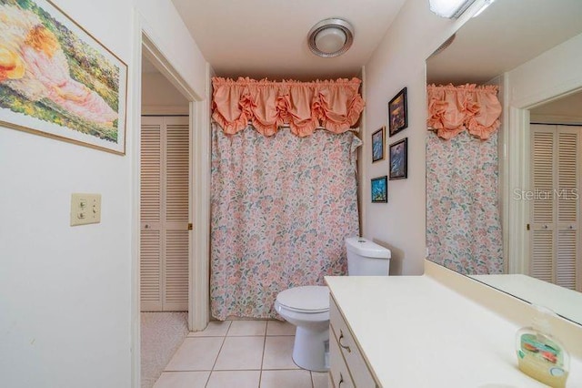 bathroom with tile patterned flooring, vanity, and toilet